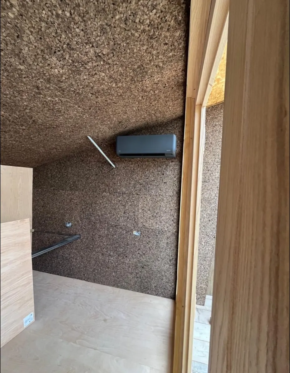 Dark wall-mounted indoor air conditioning unit installed by Warner Climate Co.
